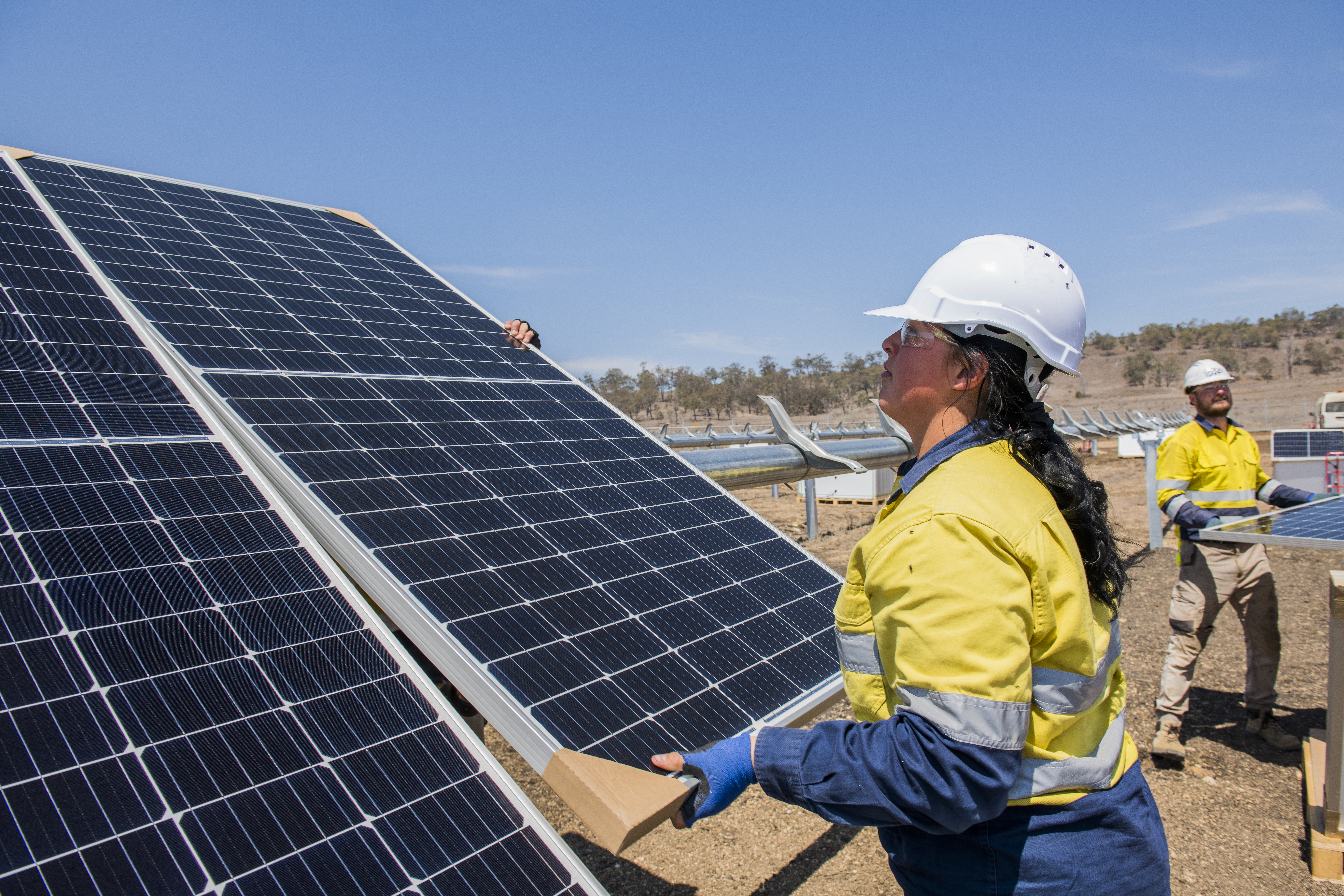Workers installing solar panels in a solar farm in Australia.